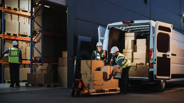 Courier loading parcels and boxes into a delivery van